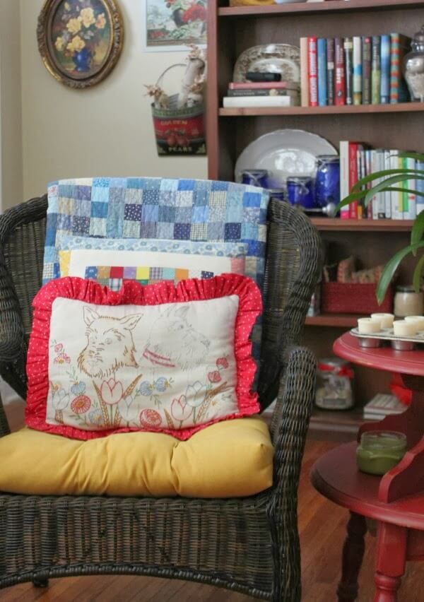 A quilt over a chair and a quilted pillow top shows my joy of quilting