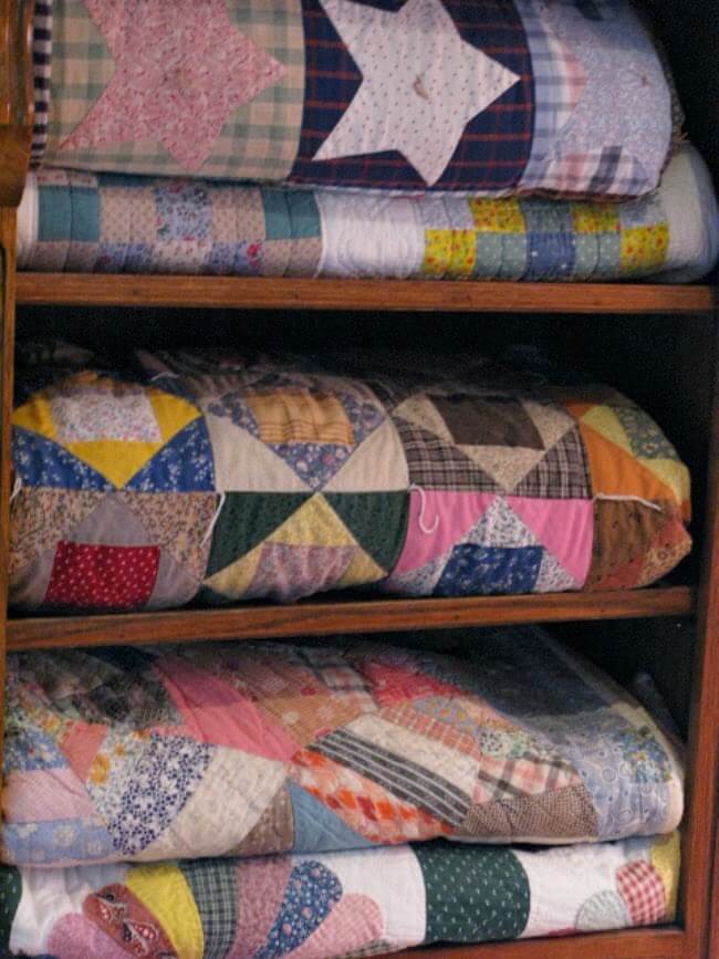 In this bookcase I have folded quilts I began to make when I discovered the joy of quilting.