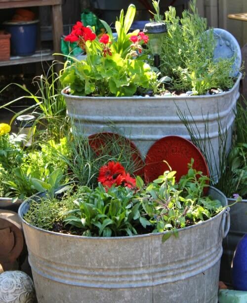 In creating an outdoor focal point, I layered old vintage galvanized containers on top of one another with plants inside them.