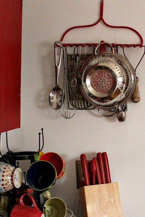A rake end I painted red and hung on the wall for vertical storage.