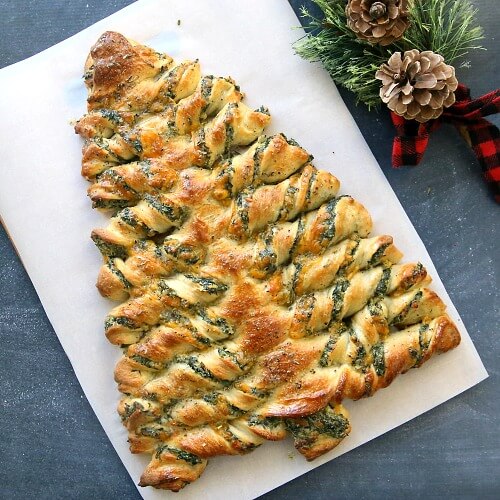 In 10 Christmas-Themed Appetizers, this is a Christmas Tree Spinach Dip Bread Sticks recipe by It's Always Autumn.