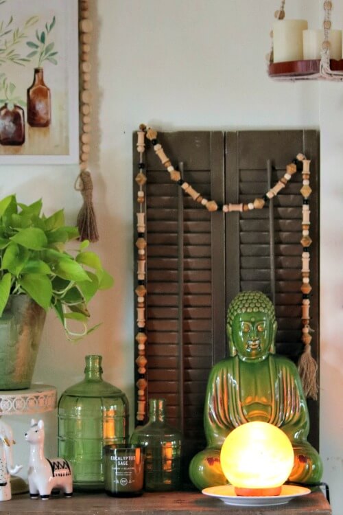 A spring boho vignette with my green Buddha in front of brown shutters