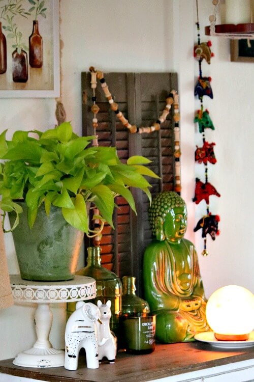 There is a salt lamp at the front of the vignette along with a lime pothos plant