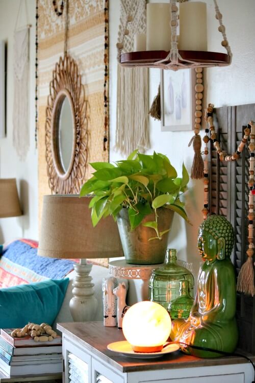 In Creating A Spring Boho Vignette, this is another view of my living room with more bohemian style decor. There is the Buddha in front of the brown shutters with a garland of beads I strung