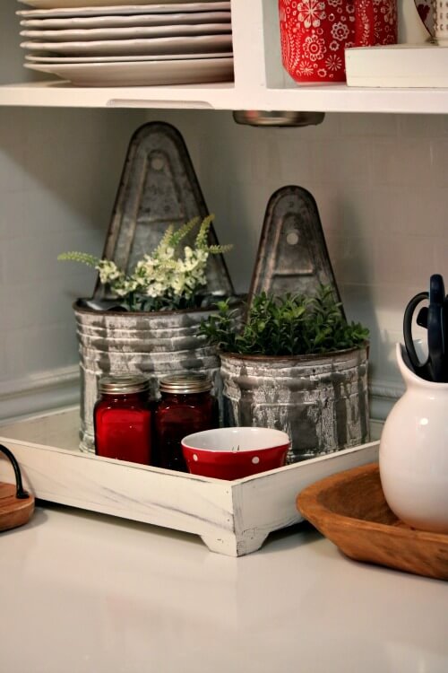 In Refreshing The Kitchen Counter Top, these are two galvanized containers with faux plants in my open kitchen shelves