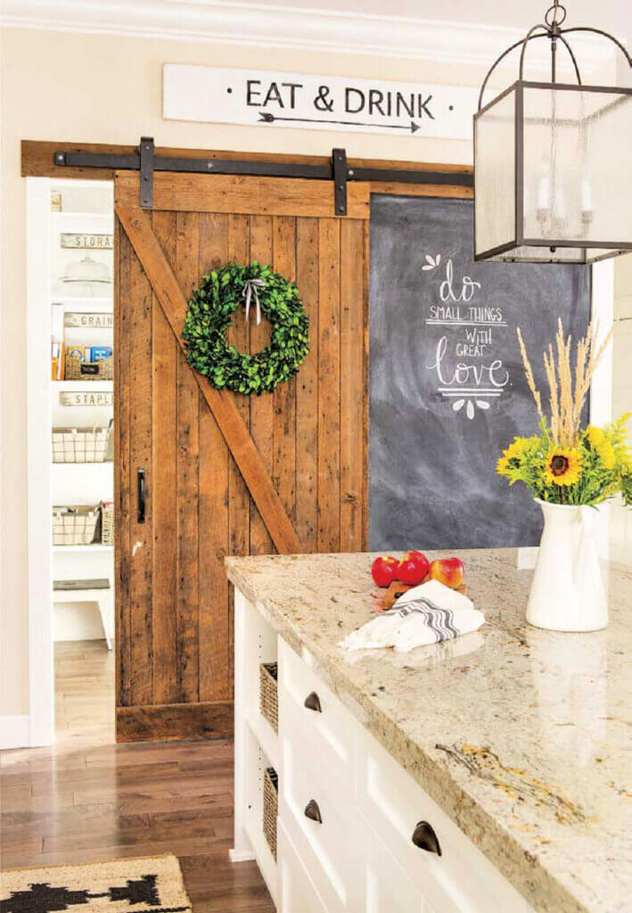 White kitchen island with granite countertop an sliding barn doors