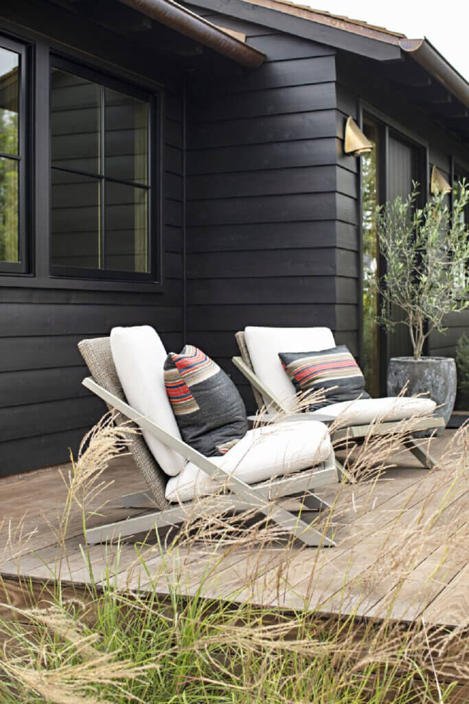 The cottage deck has two Adirondack chairs with white cushions