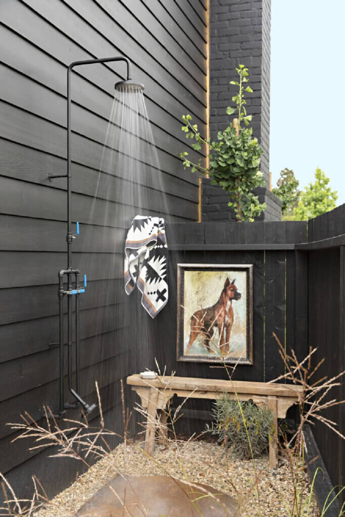This dreamy 1950s Southern California cottage has an outdoor shower with a bench and a portrait of a boxer.