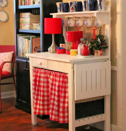 The white potting bench I painted white. It now has Christmas decor on top and a red and white gingham curtain below.