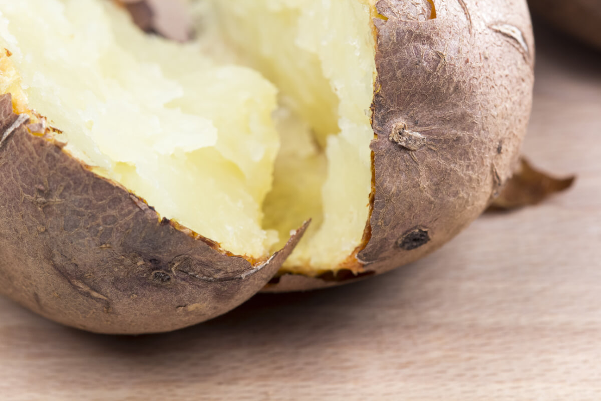 A baked potato split open and ready for butter, etc.