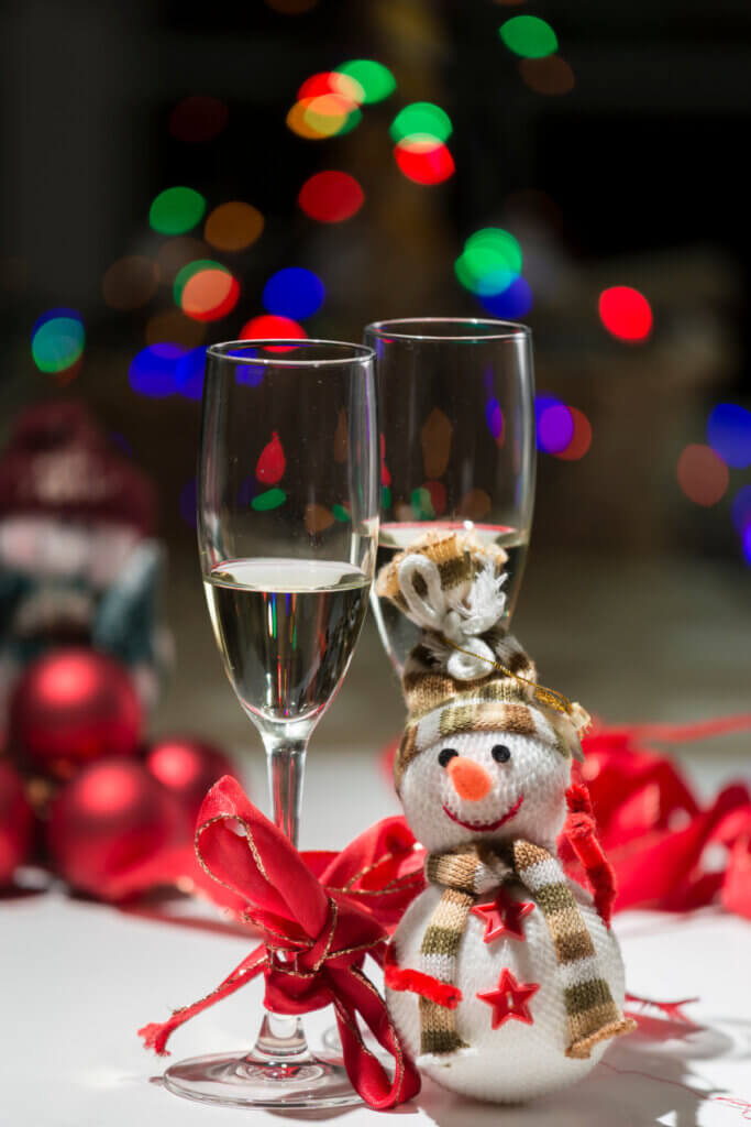 Glasses of wine and a small snowman at Christmastime