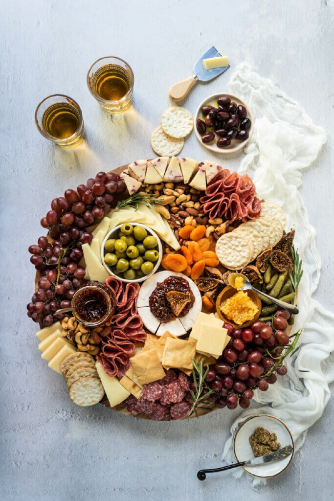 For entertaining with charcuterie boards, this one is round and has cheeses, crackers, fruits and sauces as well as nuts