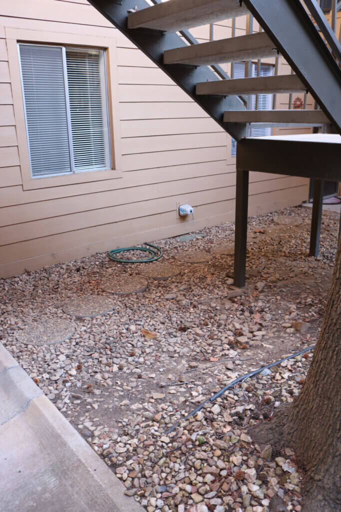 The gravel and tree area between apartments of me and my next door neighbor 