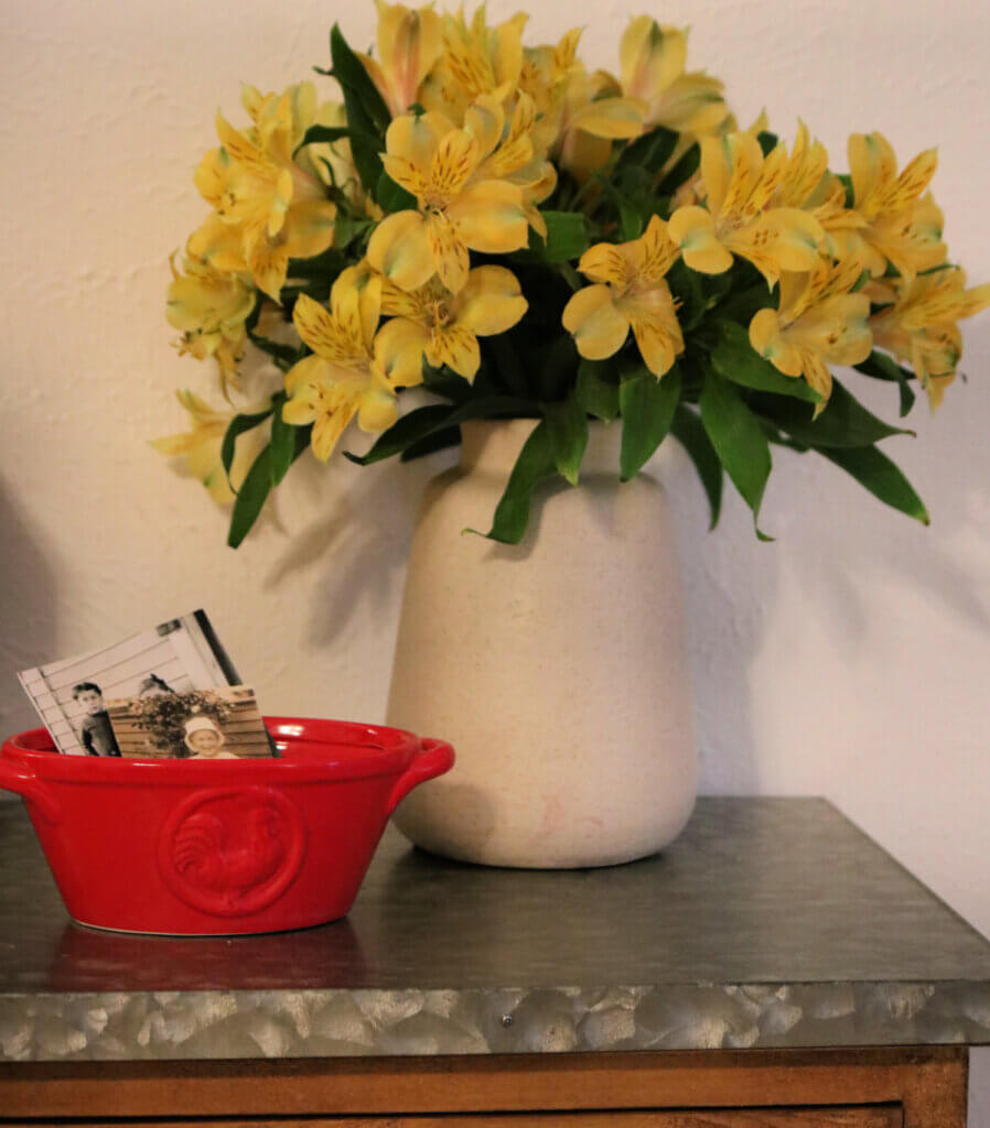 Some yellow flowers from Trader Joe's and a little red container with vintage photos of children.