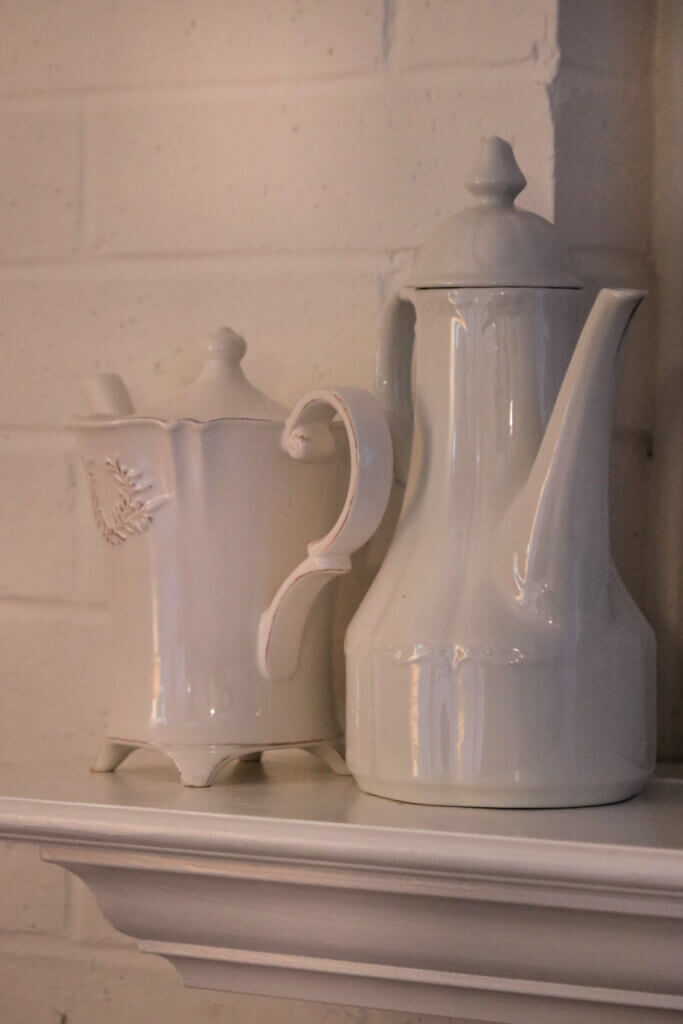 Two ironstone pitchers on the fireplace mantel