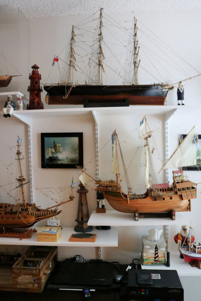On a wall in an extra room, there are shelves with some of the many ships he has built over the years.