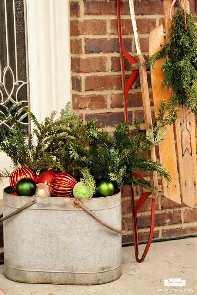 In 7 Porches Decorated For Christmas, I liked this one with ornaments and greenery and a vintage sled. 