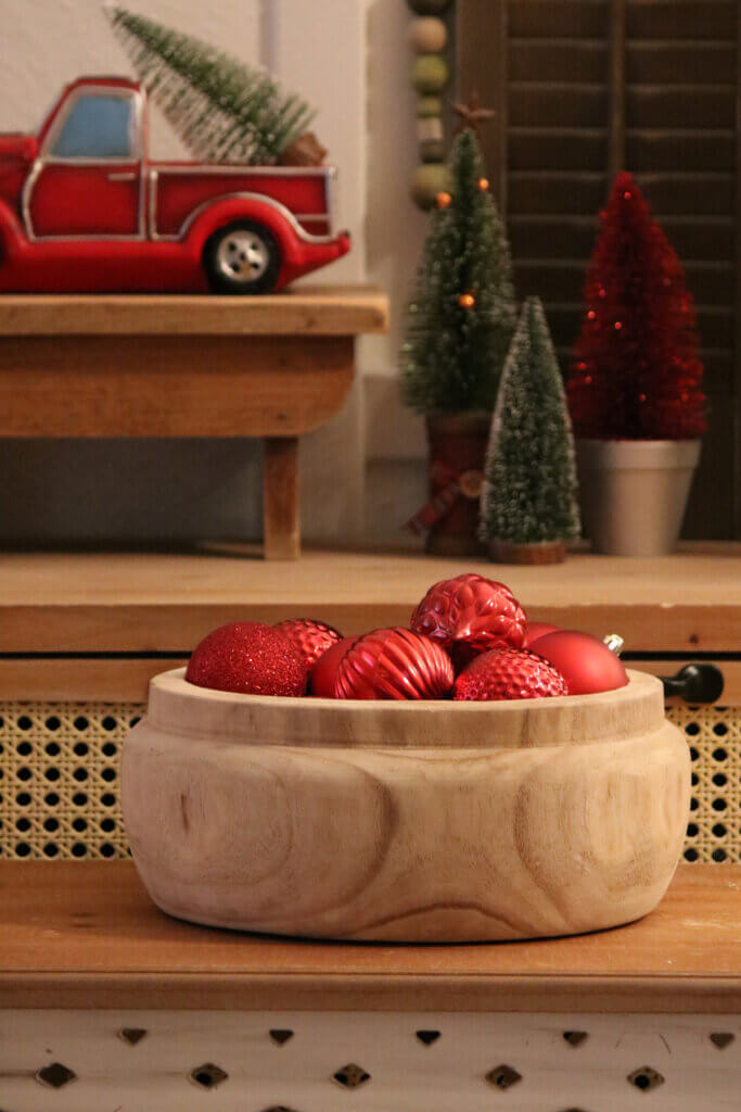 Red ornaments in a wood bowl 