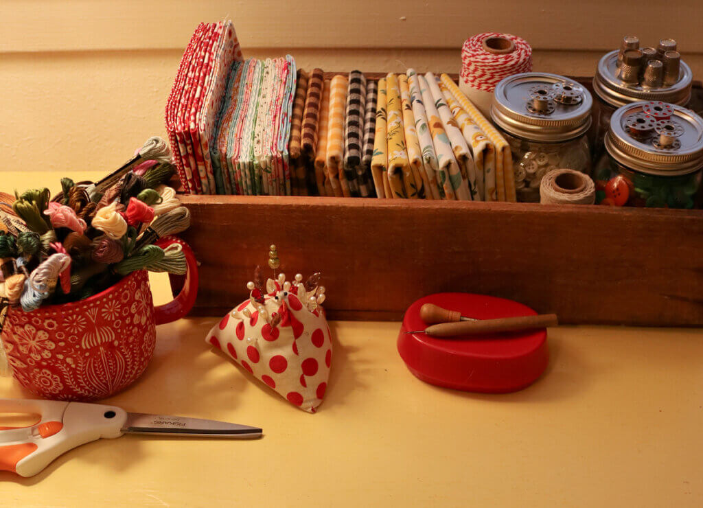Sewing notions and fabric on my yellow table in my office.