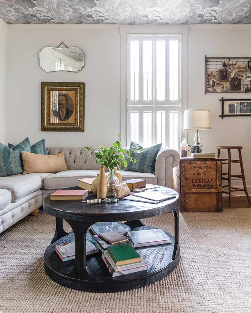 In A Charming Cottage In Tennessee. the living room has a neutral sectional and vintage decor