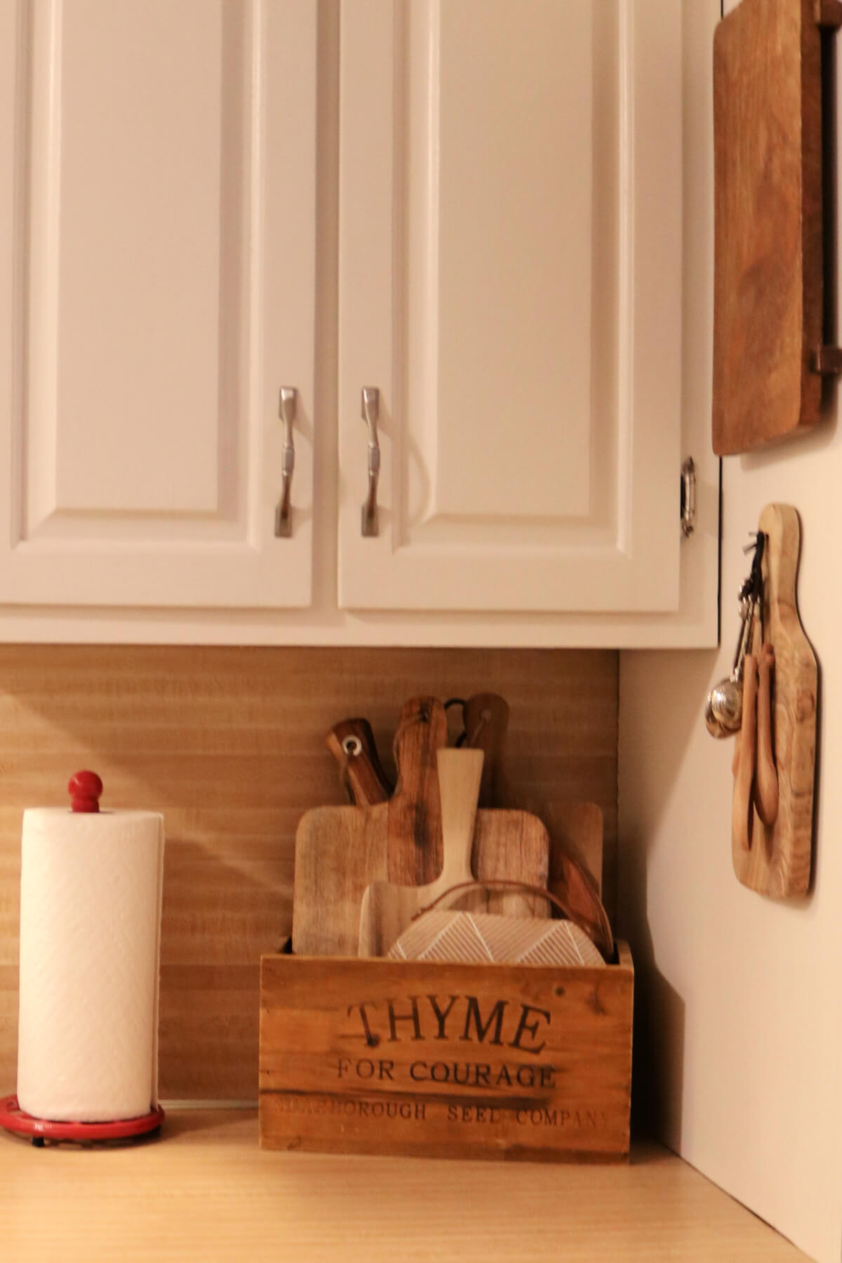 In My Refreshed & Updated Apartment Kitchen, this is where I keep various shaped cutting boards and my paper towel holder.