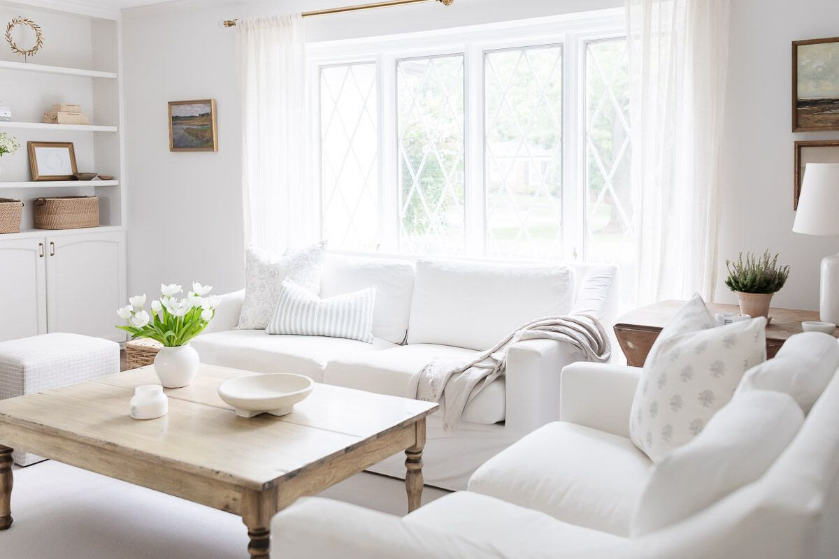 Cool airy white room with four windows and two loveseats