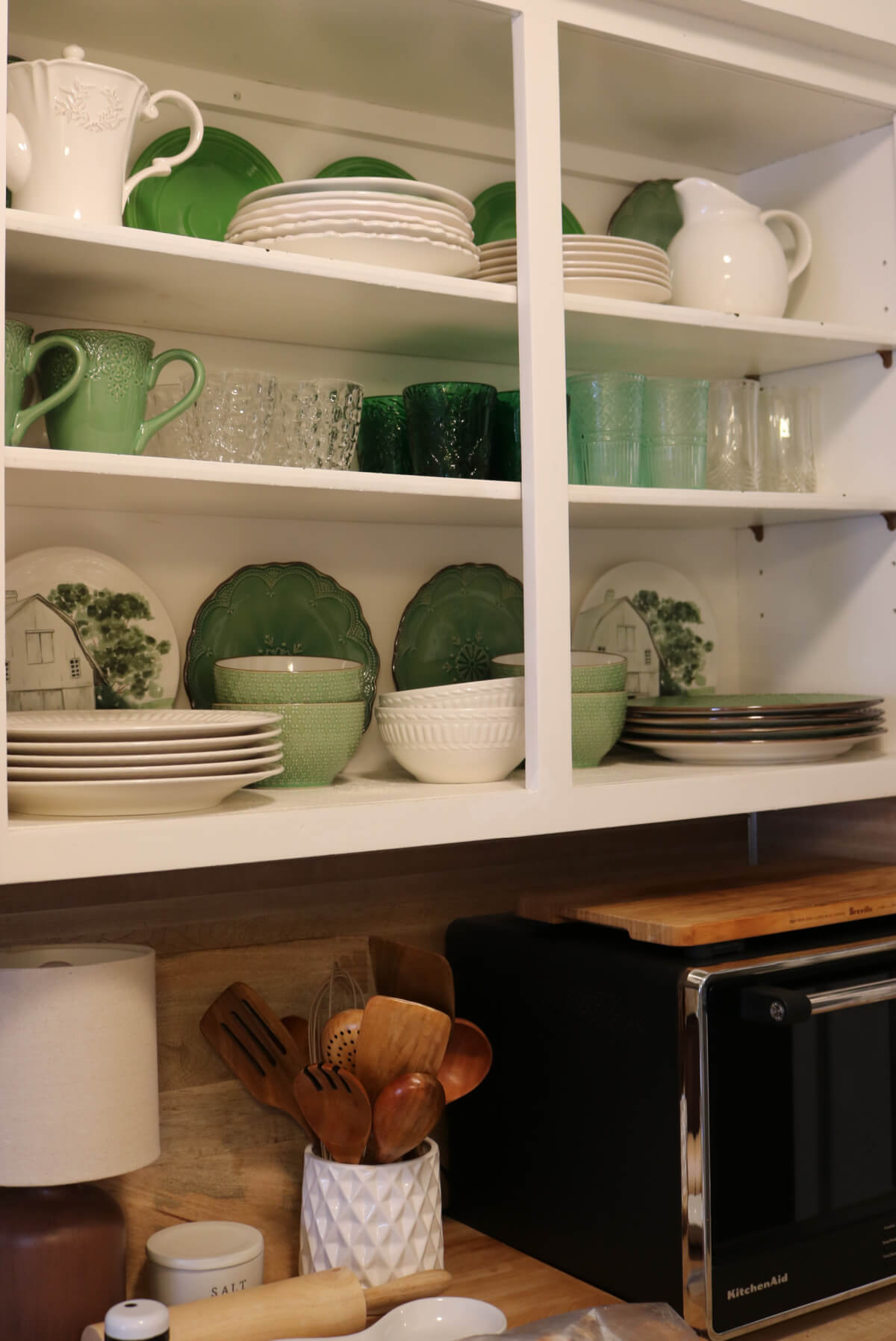 In My Apartment Kitchen Revisited For Fall, the green and white dishware in my open kitchen cabinets.