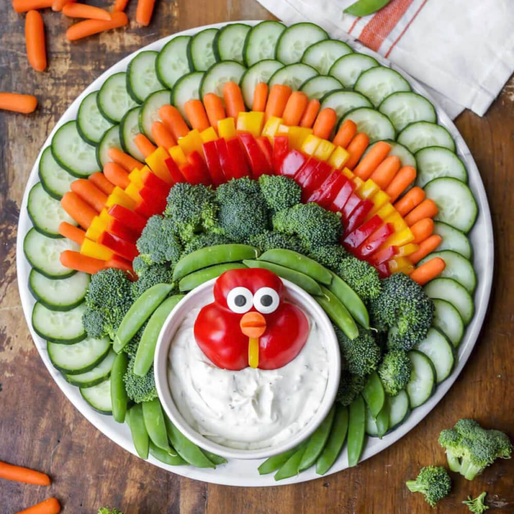 In The Love Of Home Files #4, a turkey face made out of a red pepper with lots of sliced veggies on a round plate.