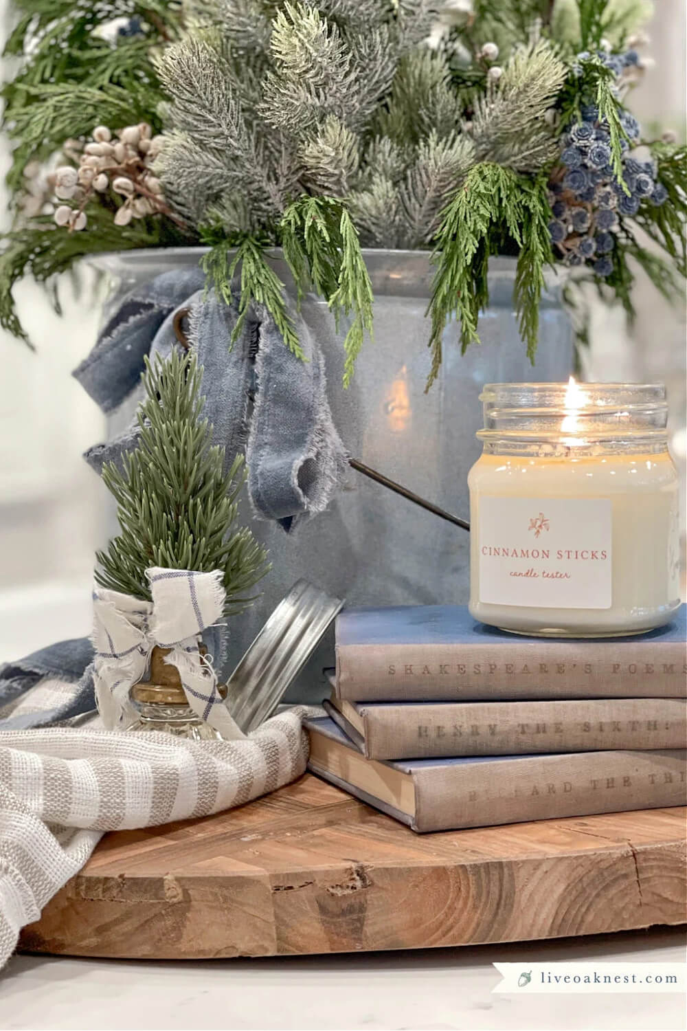 A rustic yet feminine Christmas vignette of books candles and a tree