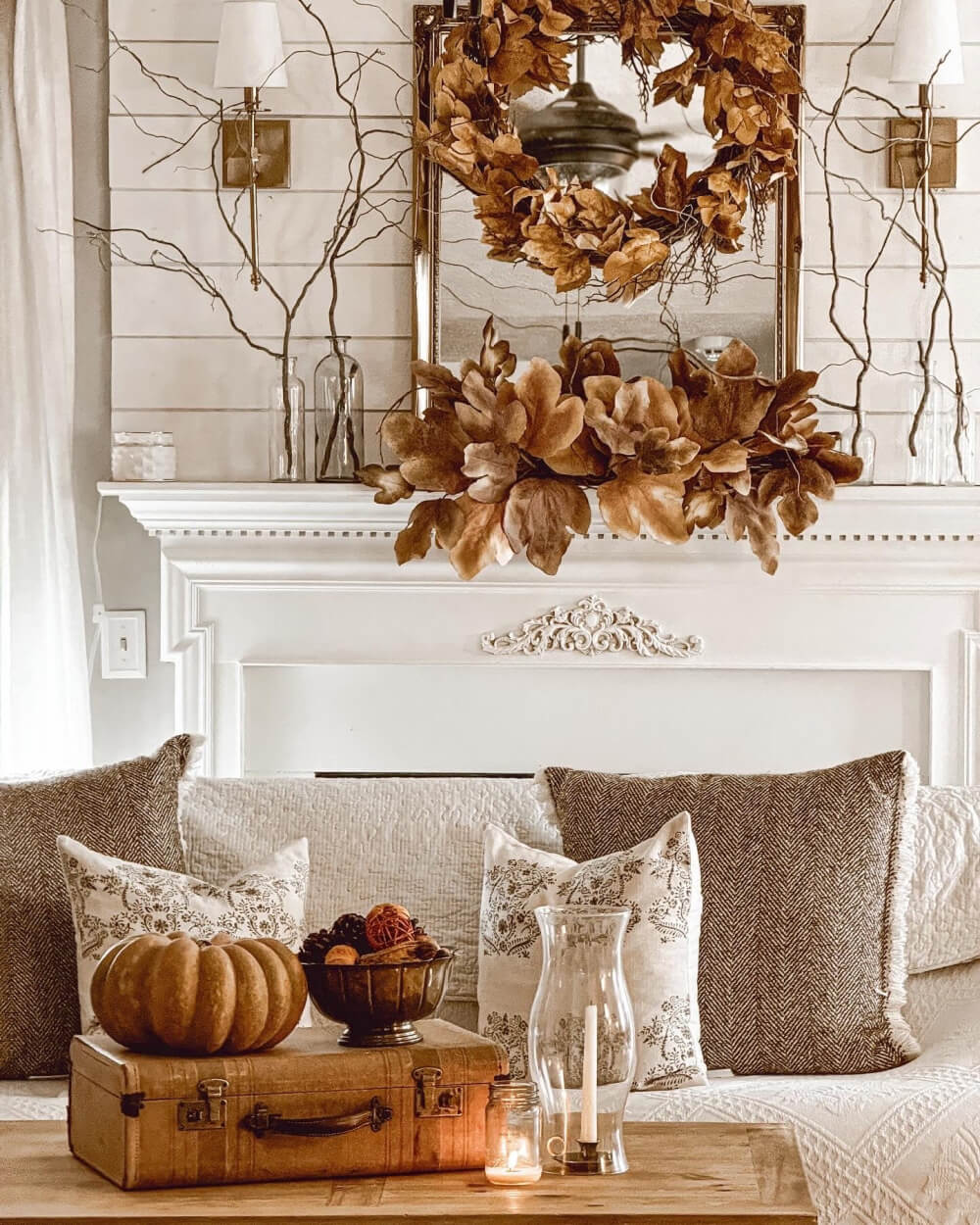 A brown themed mantel with bare sticks in clear bottles