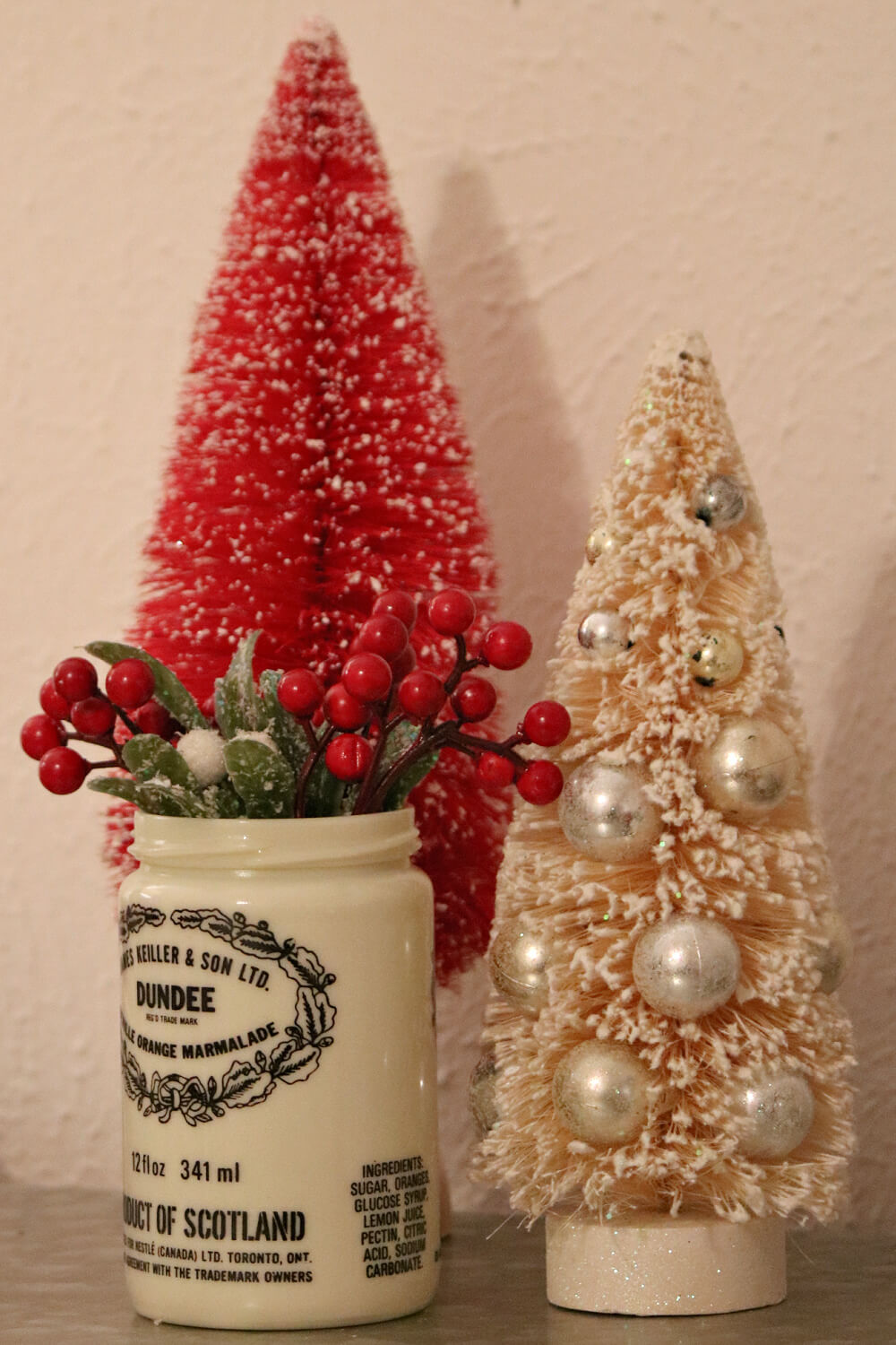 A red and cream tree with a marmalade jar of Christmas picks