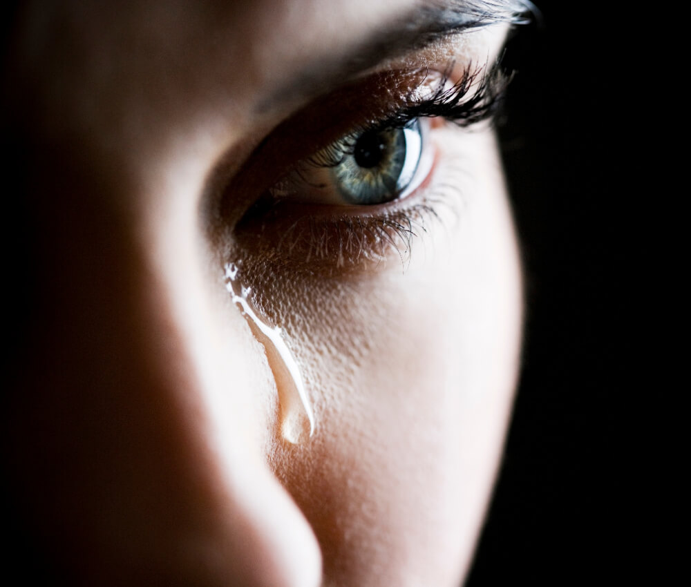 A single tear sliding down a woman's face