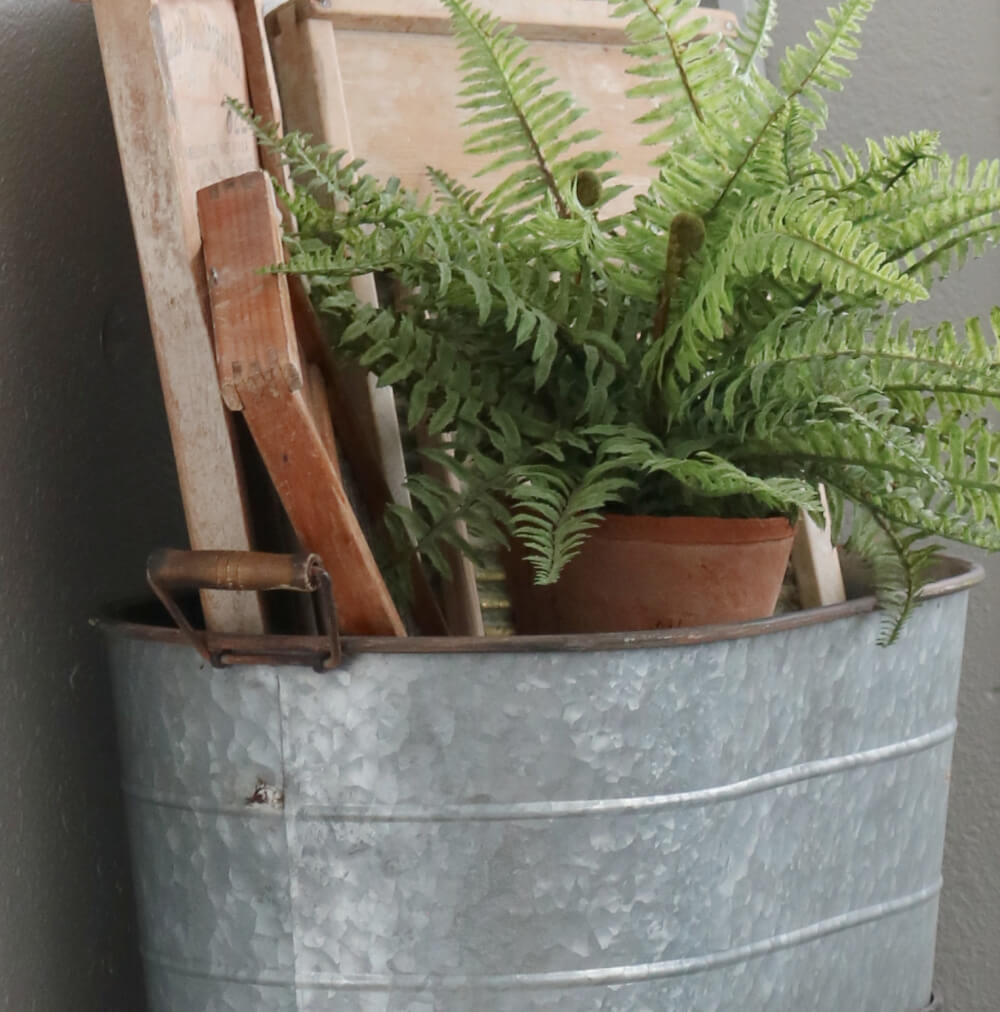 Put decorative vignettes on display with plants in a galvanized beverage tub and vintage washboards in back.