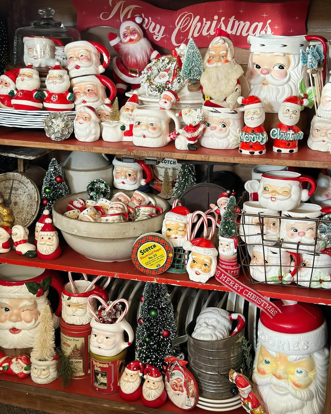 Many mugs decorate these shelves with small bottle-brush trees and other vintage holiday decor.