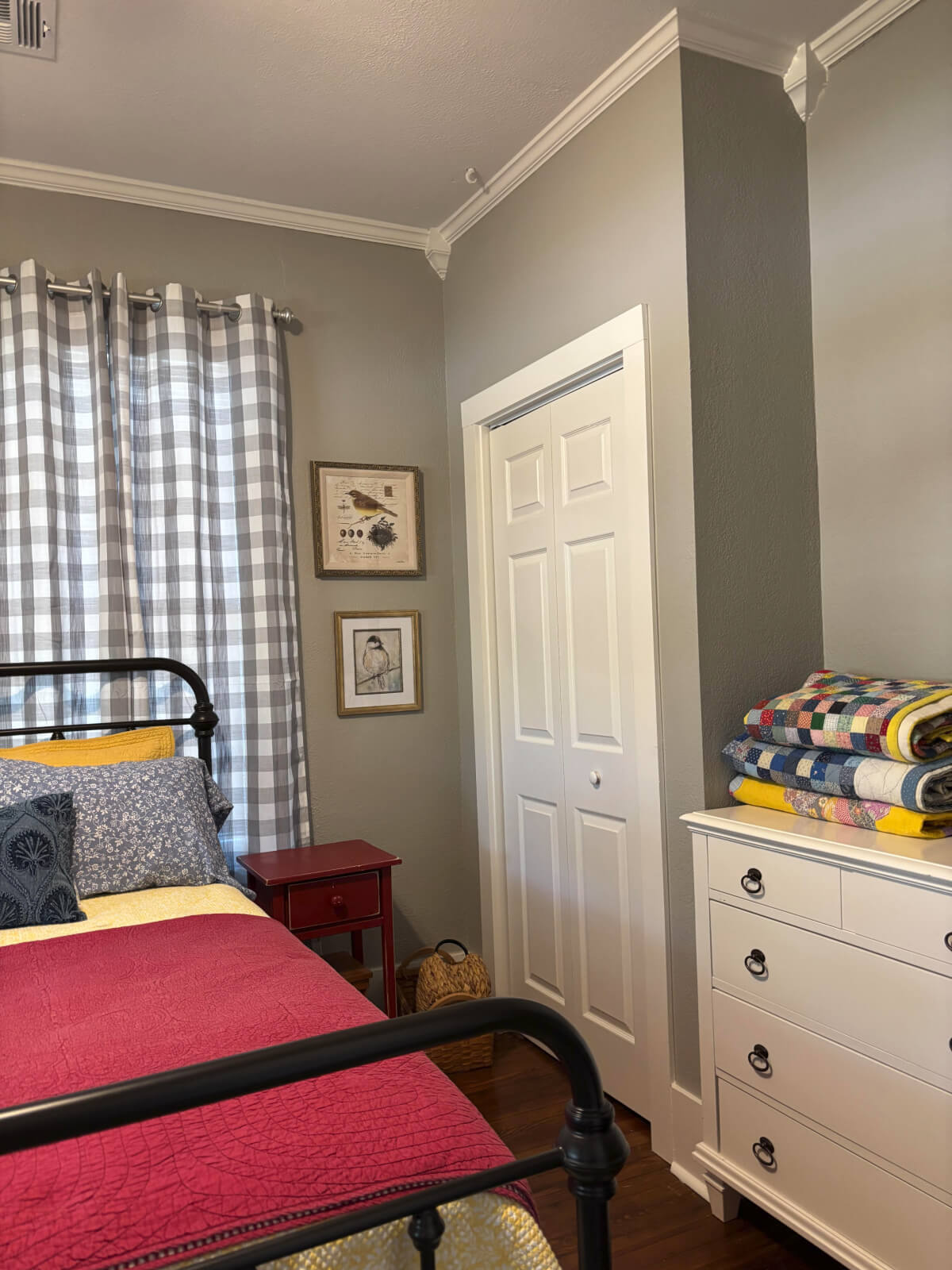 The side of the guest room with the closet and dresser with quilts.