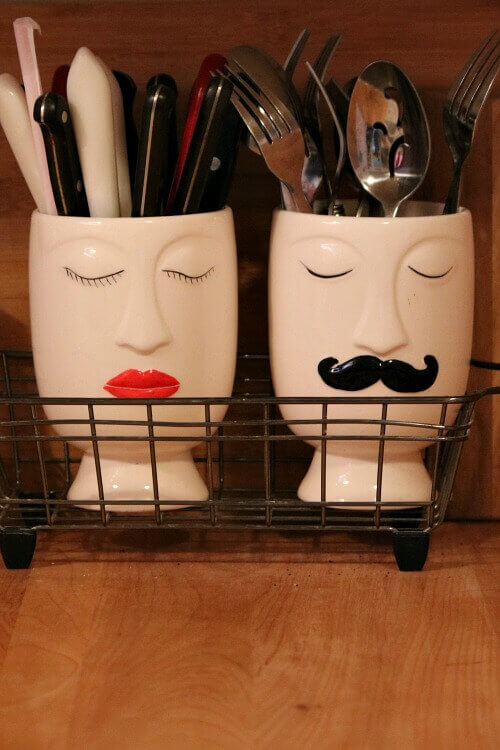 In Admiring Decor Without Wanting to Redecorate, these "people" ceramic holders has silverware in a metal dish drainer.