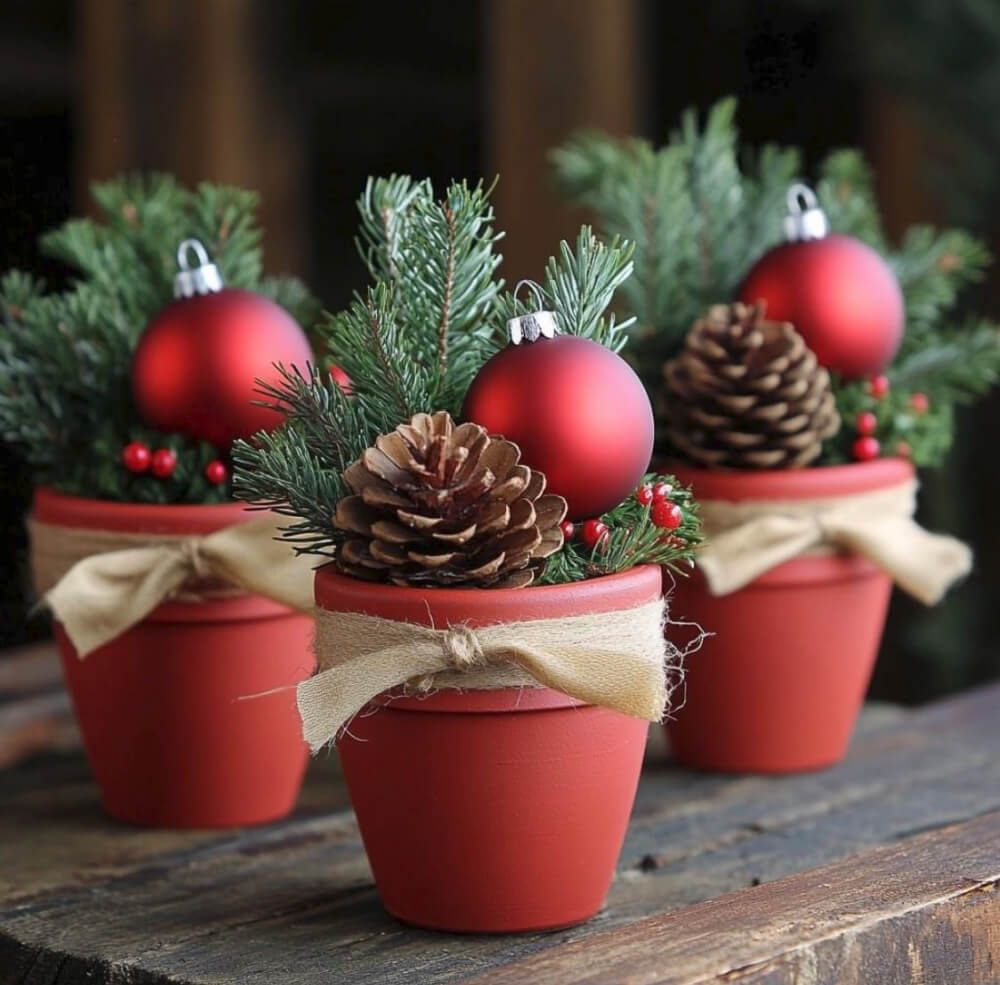 Red painted terracotta pots with red ornaments, pinecones, and greenery.