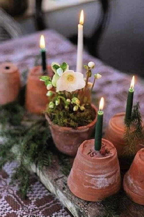 Pots turned upside down with taper candles in the hold.