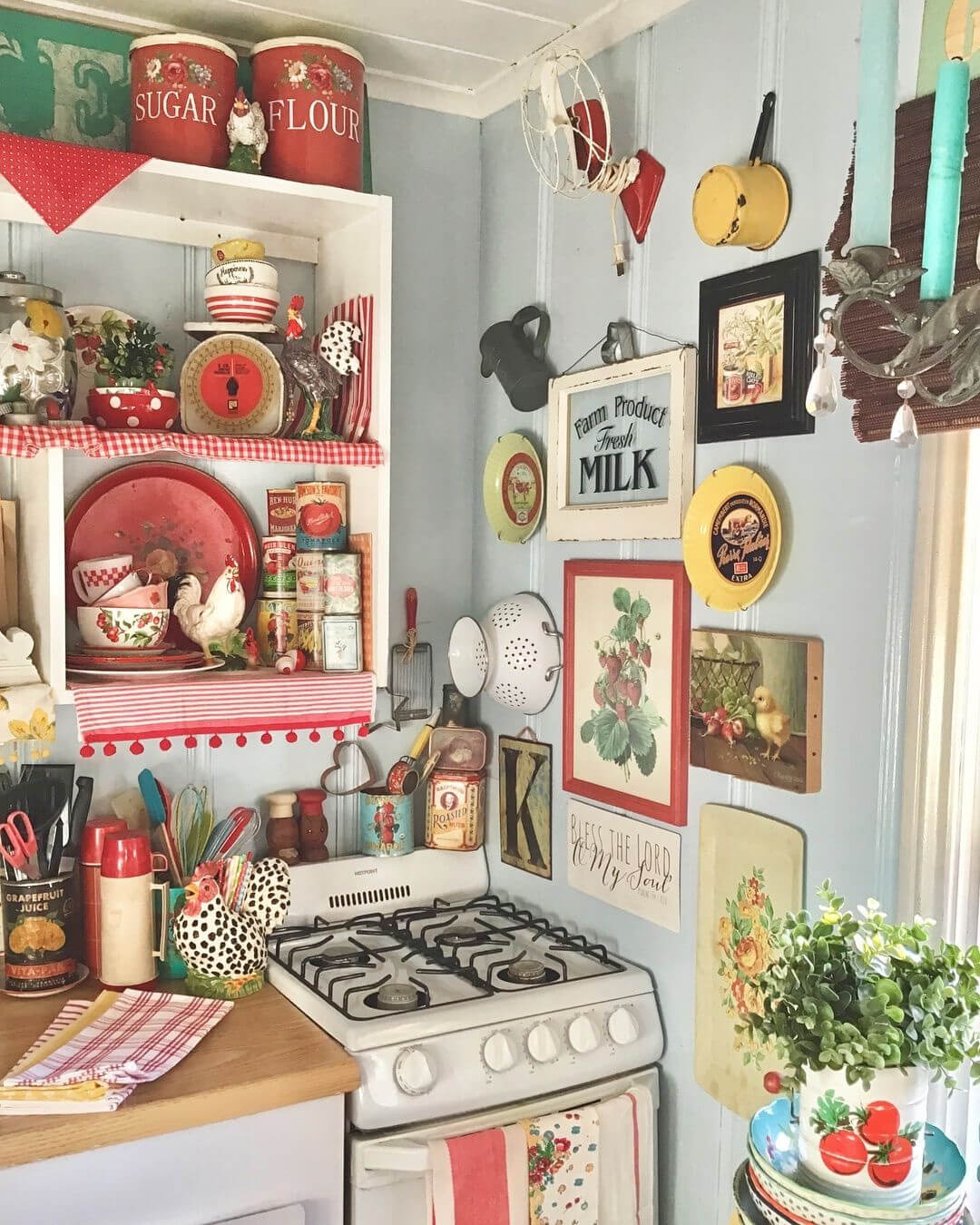 A white kitchen stove is in the corner of this kitchen, with brightly colored plaid dish towels and lots of kitschy-style decor.