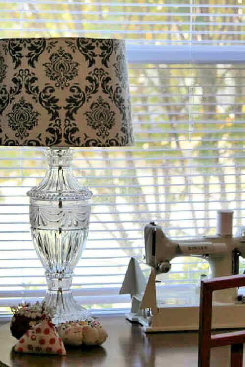 My clear glass lamp with the green and cream lampshade, and my white Singer Featherweight sewing machine.