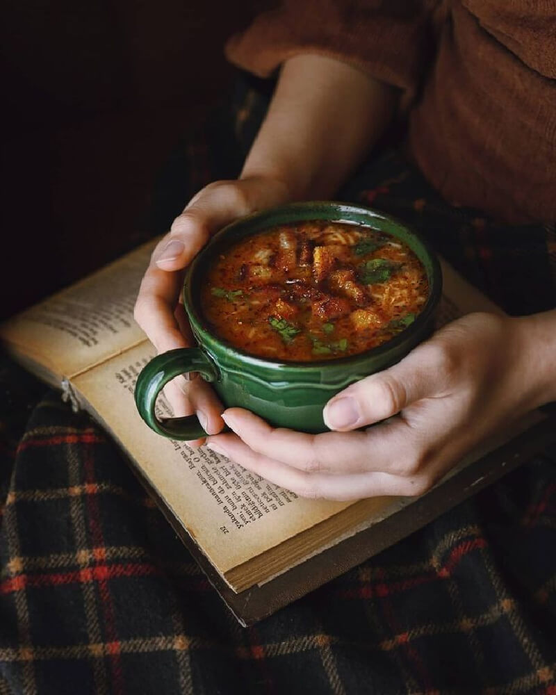 A winter wonderland of cozy moments can be found in a hot mug of soup and a book.