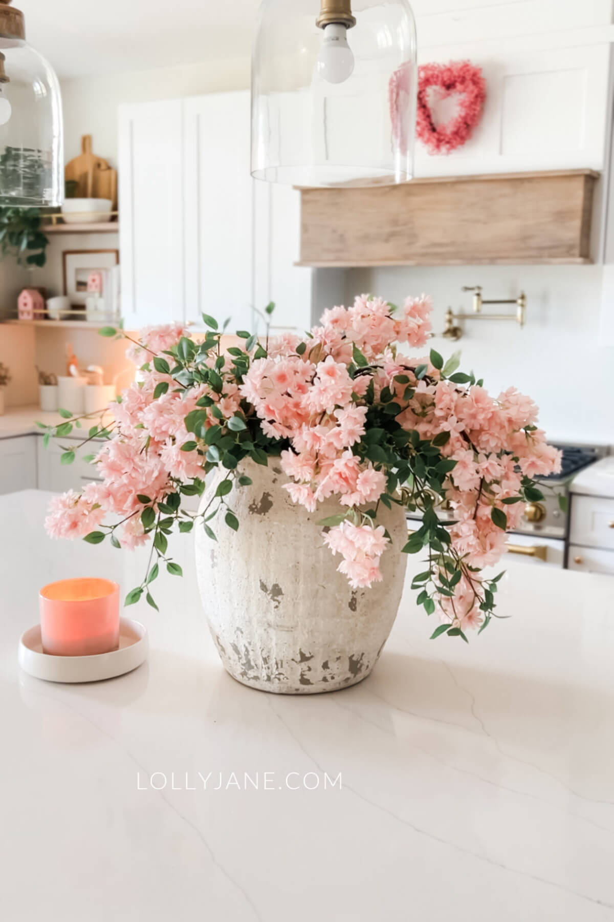 Welcome spring into your home with pretty pinkish-orange flowers with a similar colored candle.