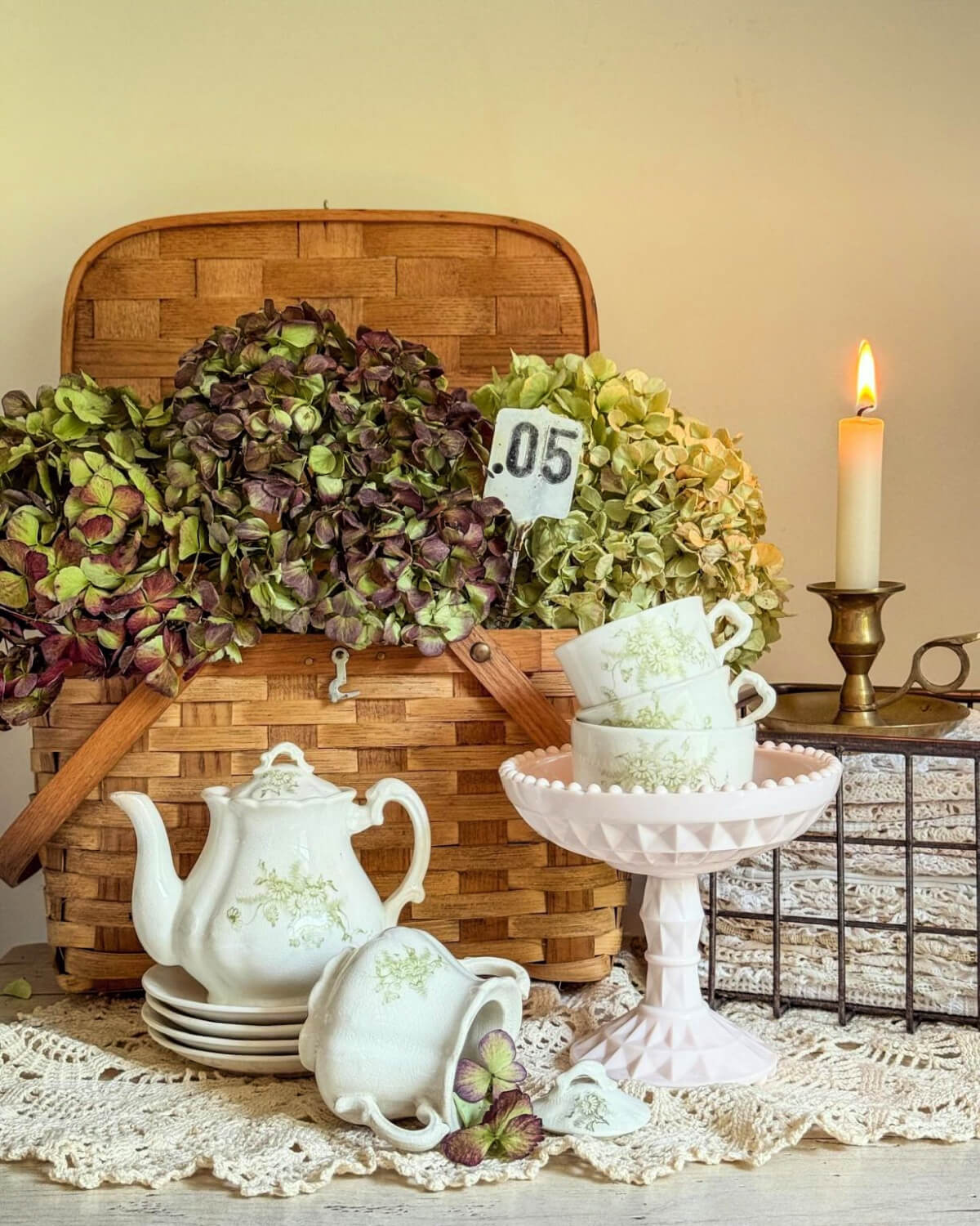 A picnic basket filled with hydrangeas, Green and white teacups and a matching pitcher complete the look.