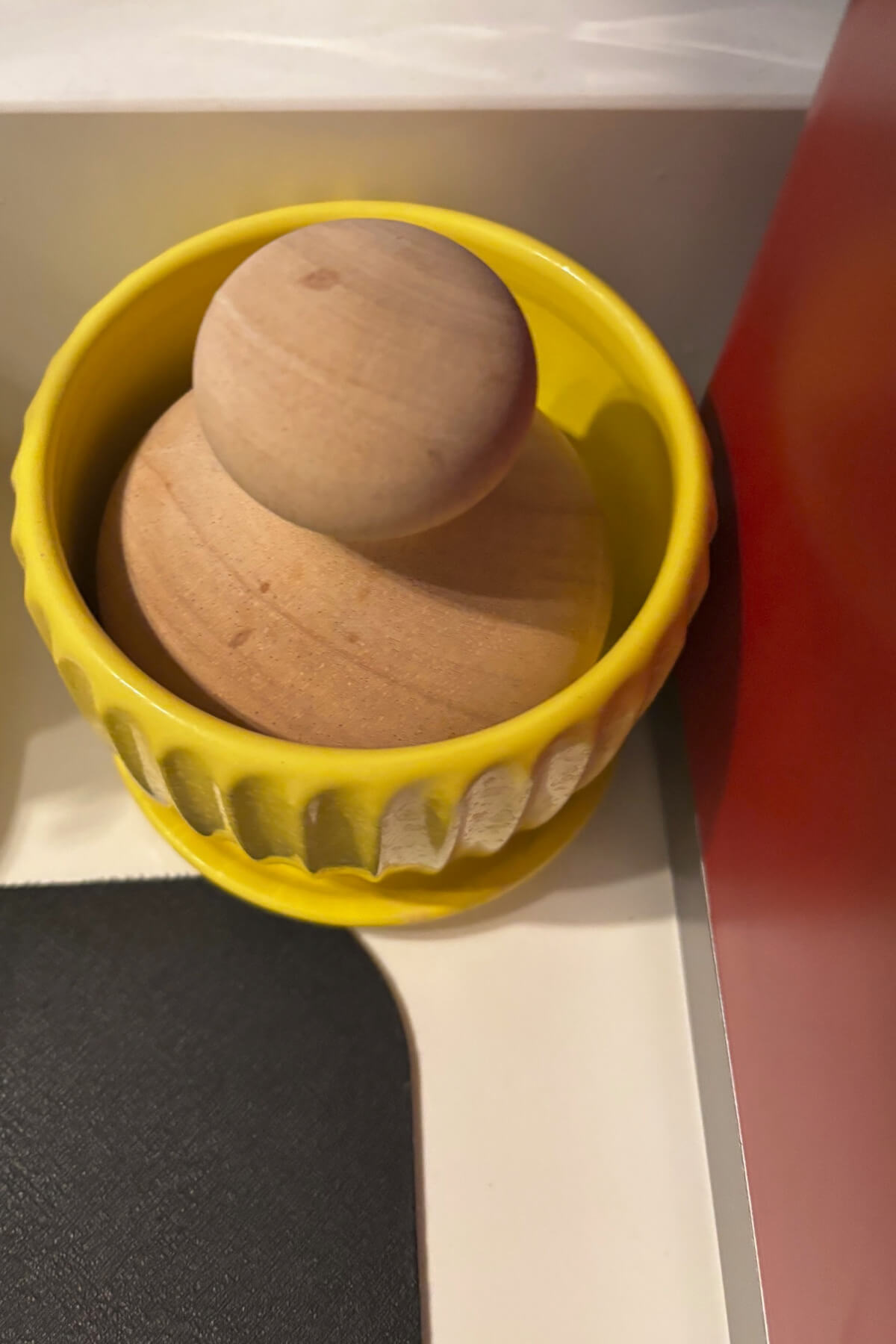 A palm dish brush in a yellow ceramic plant pot.