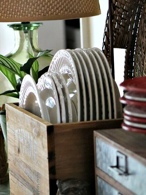 White dishes stored in a vintage wooden box.