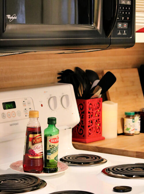 Setting kitchen oils on a pretty little red and white dish.