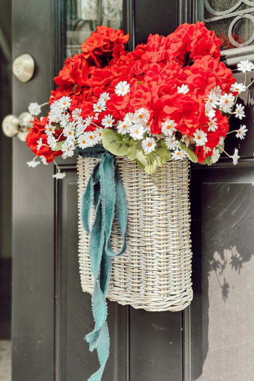 A door basket with flowers and cloth ribbon.