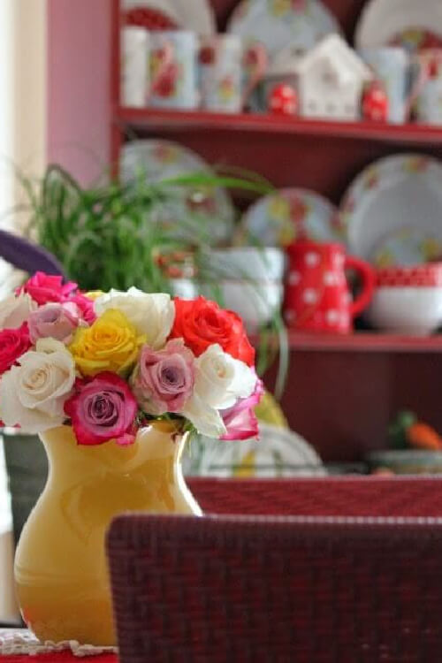 My dining room with colorful roses and checked and polka dotted dishes in the cupboard.