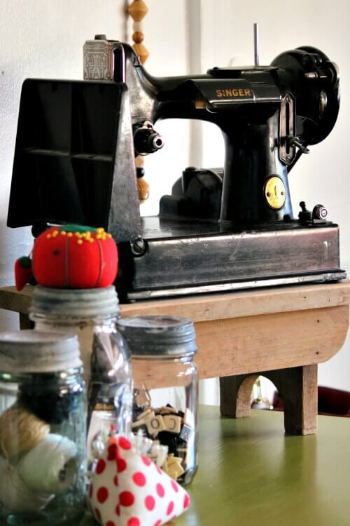 Put decorative vignettes on display with a Singer featherweight sewing machine, and vintage jars with craft supplies inside.
