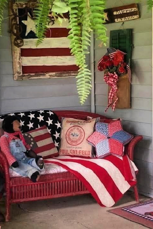 Red wicker settee with pillows.